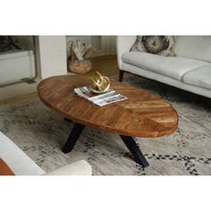 a wooden table sitting on top of a rug in a living room next to a couch