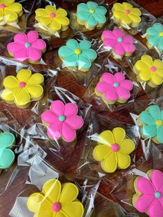 cupcakes decorated with fondant flowers in plastic wrappers on a wooden table