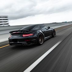 a black sports car driving down the highway