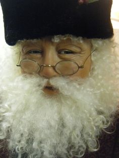 an old man with glasses and a beard wearing a fake santa clause hat on top of his head