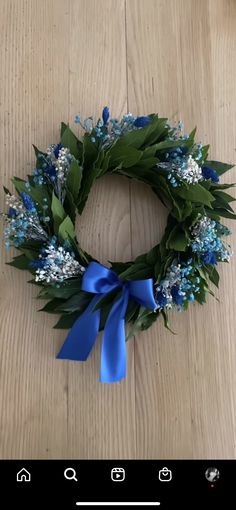 a blue and white wreath on top of a wooden floor next to a cell phone