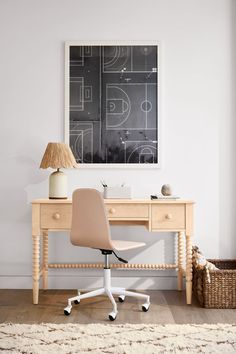 a desk with a chair and lamp in front of a chalkboard on the wall