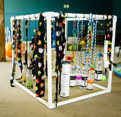 a rack with bottles and ties hanging from it's sides in a room filled with toys