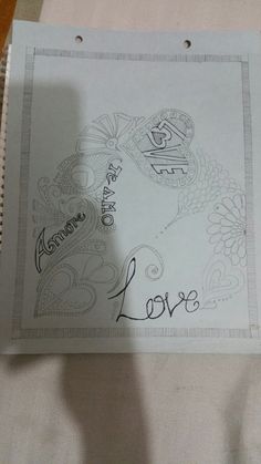 a piece of paper with the word love written on it and a drawing of a dragon