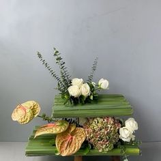 two green benches with flowers and plants on them