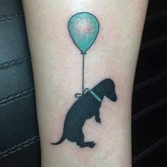 a dog with a balloon tattoo on its leg