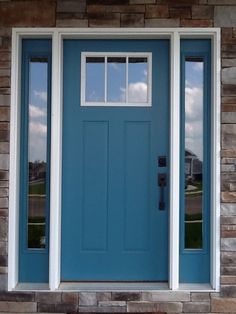 a blue front door with two sidelights on the outside and brick wall behind it