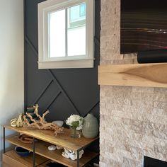 a living room with a fireplace and stone wall