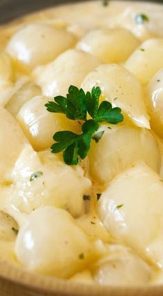 a bowl filled with potatoes and parsley on top of a table