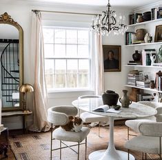 a living room filled with furniture and a cat sitting on top of a white table