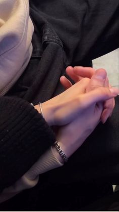 two people holding hands while sitting next to each other