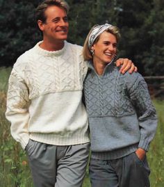 a man and woman standing next to each other in front of some tall green grass