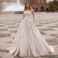 a woman wearing a wedding dress standing on a checkered floor in front of a fountain