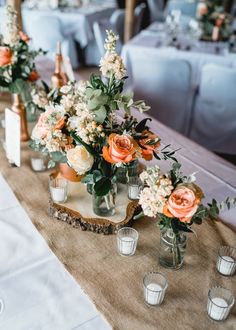 an arrangement of flowers and candles on a table