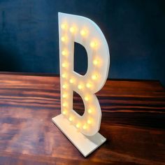 a light up letter b sitting on top of a wooden table