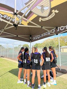 a group of young women standing under a tent