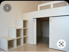 an empty room with white shelving and open closet doors