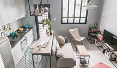 a living room filled with furniture next to a kitchen