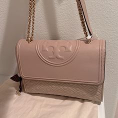 Tory Burch Fleming Convertible Shoulder Bag - New Mink/670 Details & Care : Signature Quilting And A Trapunto Embossed Logo Style This Supple Lambskin Bag That Can Be Worn Crossbody Or Easily Double The Strap And Wear As A Shoulder Bag. Magnetic-Snap Flap Closure Pull-Through & Convertible Chain Strap Exterior Slip Pocket Interior Wall And Zip Pockets Leather Imported Condition : New With Tags - Brand New, Never Worn, Kept In The Dust Bag Size Info : 10 1/2"W X 7 1/2"H X 3"D. (Interior Capacity: Elegant Beige Double Flap Bag, Double Flap Shoulder Bag With Dust Bag, Beige Double Flap Shoulder Bag For Travel, Beige Double Flap Bag With Detachable Strap, Elegant Bags With Adjustable Strap And Double Flap, Chic Beige Double Flap Shoulder Bag, Elegant Double Flap Satchel, Tory Burch Fleming Convertible Shoulder Bag, Tory Burch Bucket Bag