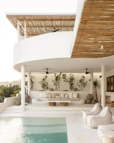 the inside of a house that has a pool and lounge area in front of it