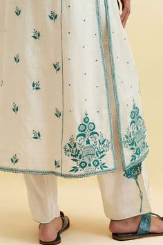 Off white panelled kurta with teal thread embroidered floral vine motifs and ric rack detail. Comes with pant, slip and scalloped dupatta. - Aza Fashions Transitional Off White Kurta With Floral Embroidery, White Semi-stitched Kurta With Intricate Embroidery, Transitional Semi-stitched Floral Embroidered Kurta, Semi-stitched Blue Kurta With Floral Embroidery, High-end Cotton Kurta With Cutdana Details, White Kurta, Kurta With Pants, White Paneling, Floral Vine