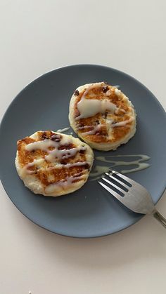 two pancakes on a blue plate with a fork