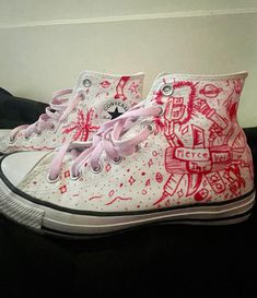 a pair of white and red shoes with designs on them