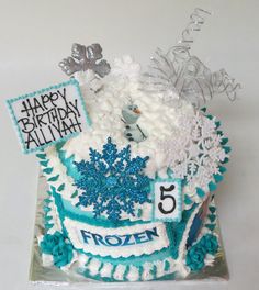 a frosted birthday cake decorated with snowflakes and icing for a frozen theme