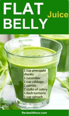 a glass filled with green juice on top of a table