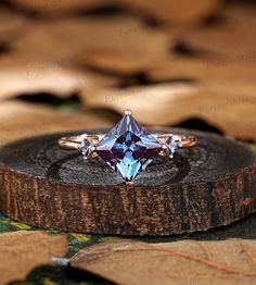 an engagement ring with a blue topazte surrounded by leafy brown and green leaves