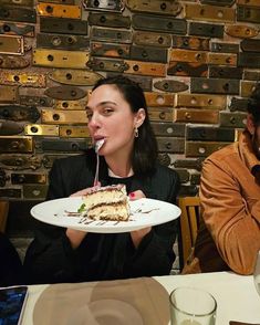 a man and woman sitting at a table with a slice of cake in front of them