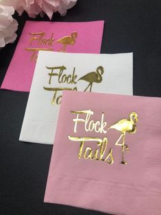 three pink and gold napkins with flamingos on them