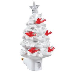 a white ceramic christmas tree with red birds on it's top and a star on the top