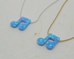 two necklaces that have musical notes made out of blue opales and gold chains