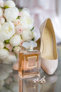 a pair of shoes and a perfume bottle on a table