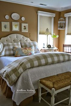 a large bed sitting in a bedroom next to two window sill with pictures on the wall