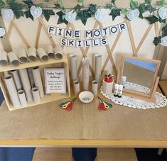 a table topped with lots of crafting supplies next to a sign that says fine motor skills