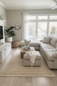 a living room filled with furniture and a flat screen tv on top of a wooden floor