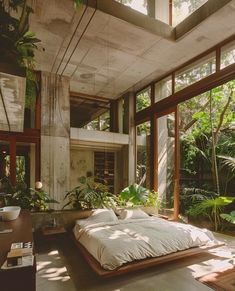 a bed sitting in the middle of a room with lots of plants on top of it