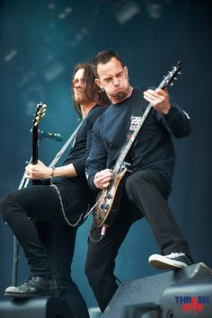 two men are playing guitars on stage