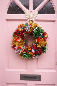 a pink door with a wreath hanging on it