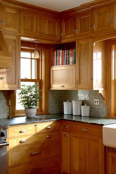 a kitchen filled with lots of wooden cabinets and counter top space next to a window