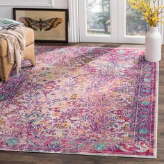 a pink rug with an ornate design on the floor in front of a door and window