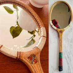 a wooden mirror sitting on top of a table next to a vase with flowers in it