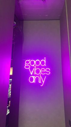 a purple neon sign that reads good vibes only on the side of a wall