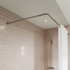 a bathroom with a tub, shower head and hand rail in the middle of it