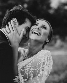 black and white photo of bride and groom hugging each other in front of the camera