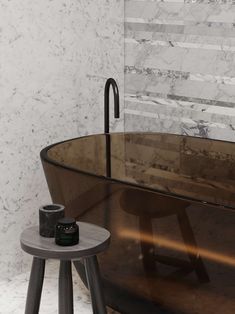 a bath tub sitting next to a table with a cup on it's side