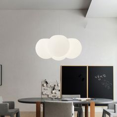 a dining room table with four chairs and a chalkboard on the wall behind it