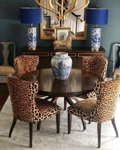 a dining room table with leopard print chairs